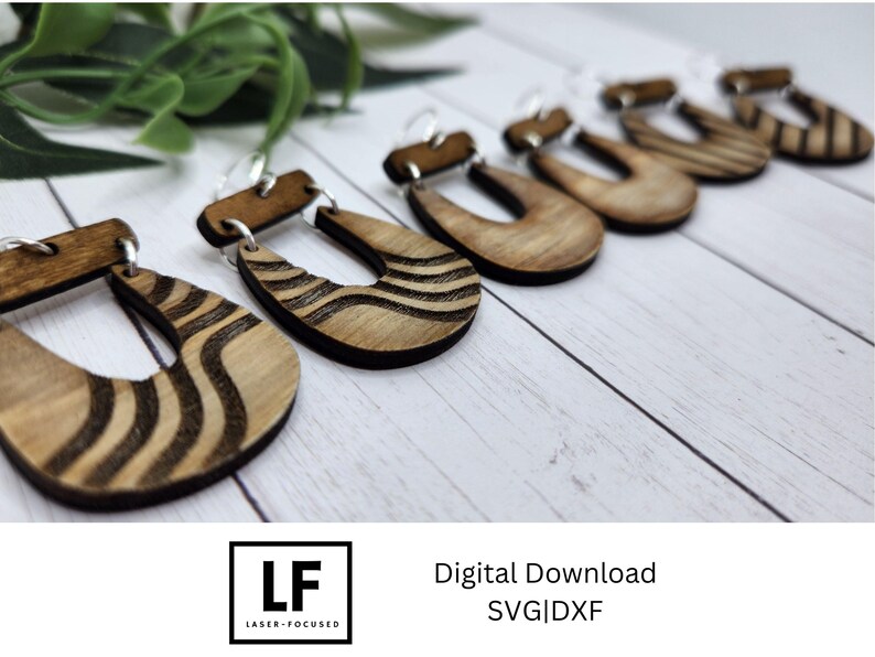 May include: Five pairs of wooden earrings with a wavy pattern. The earrings are brown and have a natural wood finish. The earrings are displayed on a white surface.