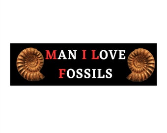 May include: Black and white sticker with the text "MAN I LOVE FOSSILS" in white letters with the word "I" in red.  Two brown fossilized ammonite shells are on either side of the text.