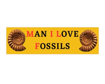 May include: A yellow banner with two brown ammonite fossils on either side of the text "MAN I LOVE FOSSILS" in black letters with the word "I" in red.