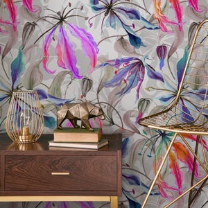 May include: A floral wallpaper featuring large, stylized flowers in shades of pink, purple, blue, and orange against a gray background. A gold wire lamp, a geometric bear sculpture, and a gold chair are also visible.