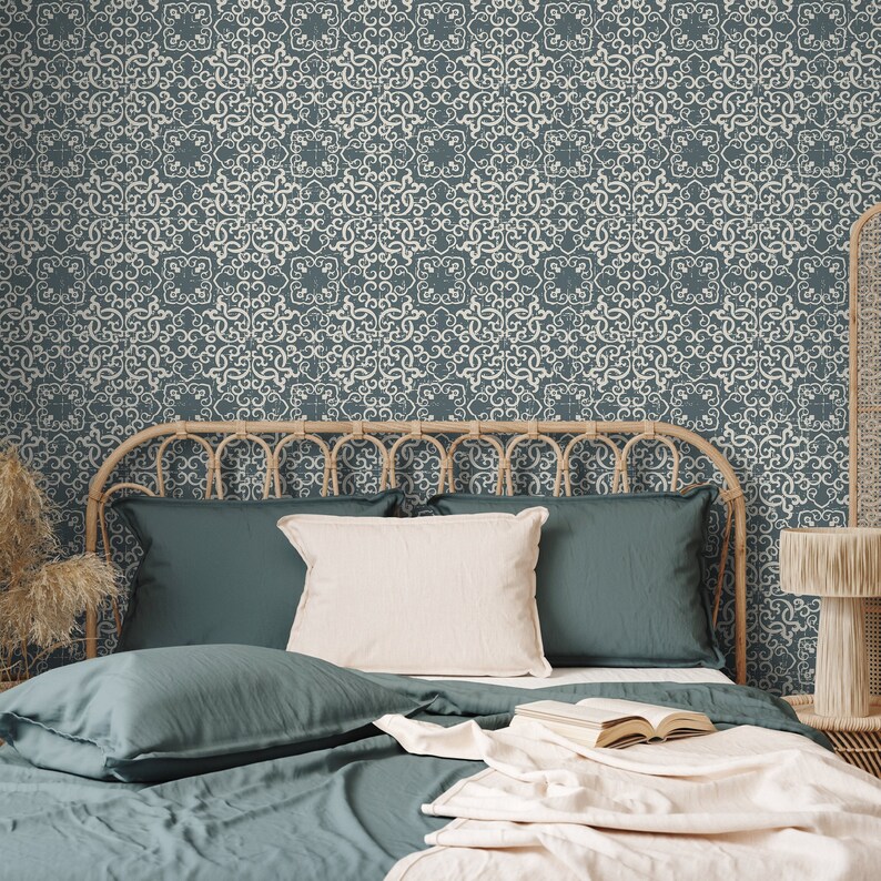 K&ouml;nnte beinhalten: Ein blaues Bett mit einem geflochtenen Rattankopfende und einer wei&szlig;en gemusterten Tapete. Das Bett ist mit einer blauen Bettdecke und Kissen sowie einer wei&szlig;en Wolldecke ausgestattet.
