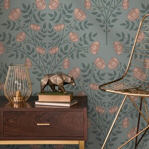 May include: A teal wallpaper with a floral pattern of pink peonies and green leaves. A gold metal chair and a gold metal bear sculpture are in the foreground.