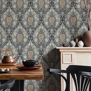 May include: A detailed shot of wallpaper with a repeating pattern of stylized teardrop shapes in gray, navy, gold, and white. The wallpaper is the backdrop for a wooden table, a black chair, and decorative items on a mantel.