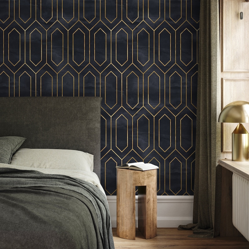 May include: A dark blue bedroom with a black headboard bed, a wooden stool, and a gold lamp. The wall is covered in a geometric wallpaper with gold lines.