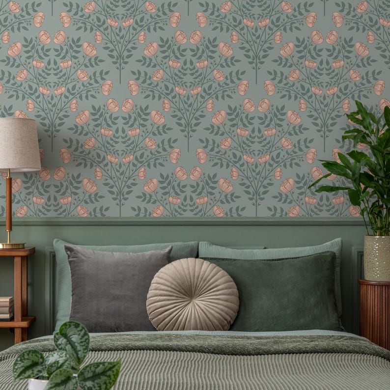 May include: A green bedroom with a bed featuring a gray duvet, two gray pillows, and a round beige pillow. The wall behind the bed is covered in a floral wallpaper with a repeating pattern of pink flowers and green leaves.