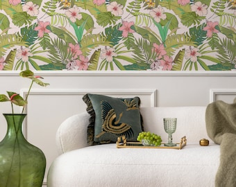 May include: A living room scene featuring a white, curved sofa with a decorative teal pillow and a gold tray holding grapes and a glass. The background showcases a tropical floral wallpaper with pink hibiscus flowers and green leaves.
