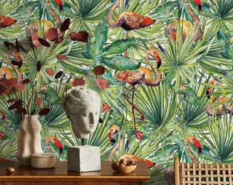 May include: Watercolor wallpaper featuring flamingos and tropical foliage in shades of green, yellow, orange, and red. The design includes a variety of palm leaves and other plants, creating a vibrant and exotic scene. A bust and other decorative items are on a wooden surface.