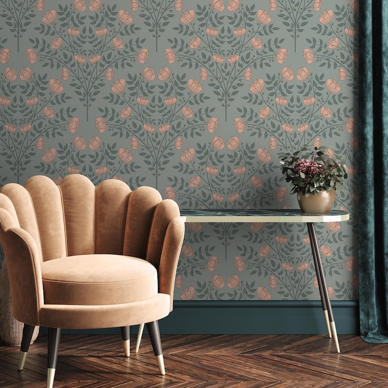 May include: A light brown, curved-back armchair sits in front of a wall with a floral wallpaper pattern. The wallpaper features a repeating design of pink flowers and green leaves on a blue background. A dark brown table with a white top sits in front of the chair.