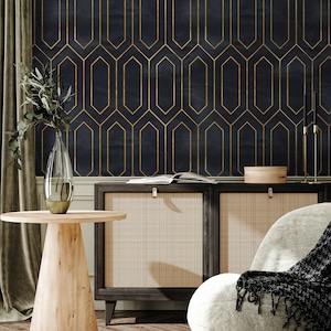 May include: A dark blue wallpaper with a gold geometric pattern. The wallpaper is behind a dark wood cabinet with a woven rattan front. A wooden side table with a vase and a chair with a black throw blanket are in the foreground.