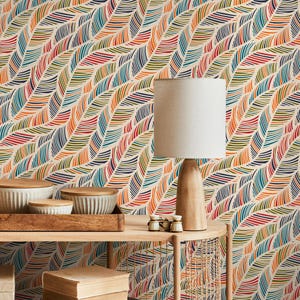 May include: A colorful wallpaper with a repeating pattern of curved, feather-like shapes in red, orange, yellow, green, blue, and navy against a cream background. A wooden lamp with a beige lampshade sits on a wooden table with decorative bowls.