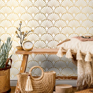 May include: A gold and white geometric patterned wallpaper with a brown wooden shelf, a wicker basket, a straw tote bag, and a throw pillow with a brown and white pattern.