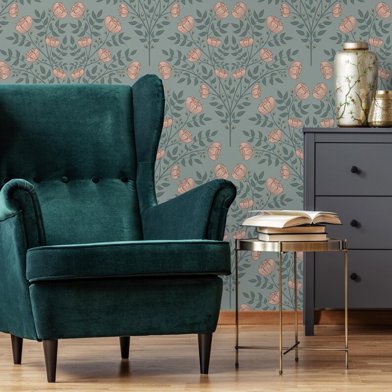 May include: A teal green armchair with a floral wallpaper background. The wallpaper features a repeating pattern of pink flowers and green leaves.