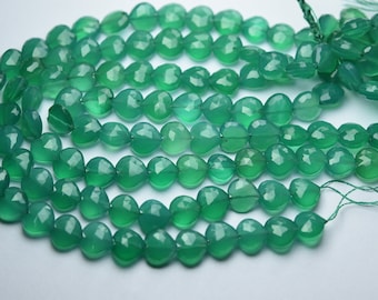 Puede incluir: Una hebra de cuentas de piedras preciosas verdes, cada cuenta es facetada y tiene forma de corazón. Las cuentas están enhebradas en un hilo fino.