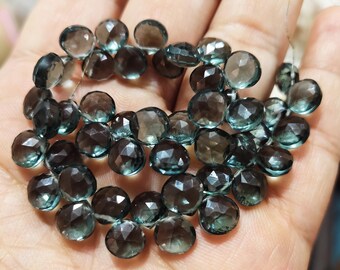 May include: A strand of faceted gemstone beads in shades of gray and green. The beads are round and have a faceted finish, giving them a sparkly appearance.
