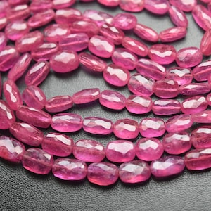Op de afbeelding: Een streng roze facetgeslepen edelsteen kralen. De kralen zijn ovaalvormig en hebben een gladde, gepolijste afwerking.