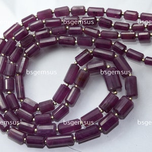 Könnte beinhalten: Eine Strähne aus violetten Edelsteinperlen, jede Perle ist facettiert und hat eine rechteckige Form. Die Perlen sind auf einem Silberdraht aufgefädelt.