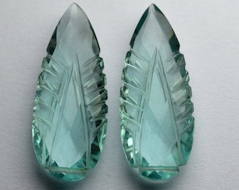 Puede incluir: Dos colgantes de piedra preciosa de color azul claro, tallados en forma de lágrima.