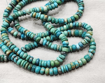 May include: Strands of turquoise beads in varying shades of blue and green. The beads are round and flat, strung together to form necklaces or bracelets. The beads have a natural, earthy appearance.