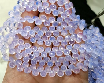 May include: A strand of faceted, light purple gemstone beads. The beads are teardrop-shaped and strung together, creating a delicate and shimmering effect. The beads are held in a hand, showcasing their color and shape. Ideal for jewelry making.