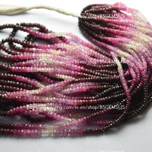 May include: Strands of faceted gemstones in shades of deep burgundy, pink, and cream. The beads are strung together, creating a gradient effect from dark to light. A white tassel is at the top. Ideal for jewelry making.
