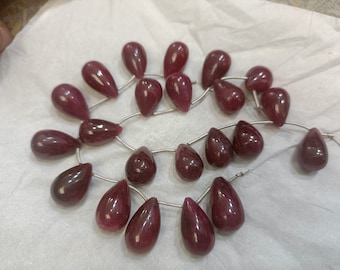 May include: A strand of 25 teardrop-shaped ruby beads, each bead is approximately 10mm in length and 7mm in width. The beads are strung on a silver wire.