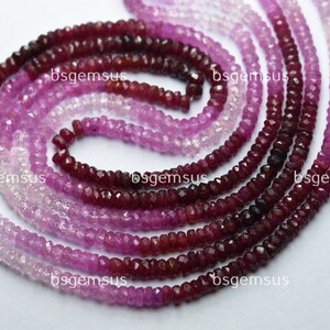 Puede incluir: Una hebra de cuentas de piedras preciosas rosadas y rojas. Las cuentas son facetadas y tienen un degradado de color de rosa claro a rojo oscuro.