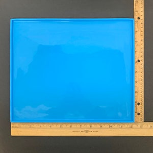 May include: A bright blue silicone baking mat with a smooth surface. The mat is 12 inches by 16 inches.