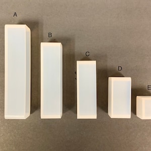 May include: Five clear silicone molds of different sizes, labeled A through E. The molds are rectangular in shape and appear to be for making soap or candles.
