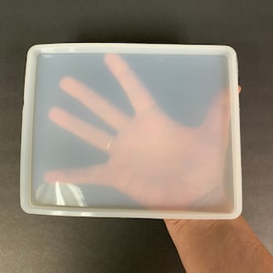 May include: A clear silicone mold with a rectangular shape. The mold is large enough to fit a hand inside.
