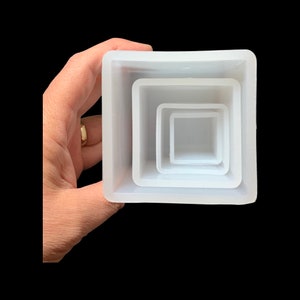 May include: A white silicone mould with four square compartments, each nested inside the other, for making resin crafts.