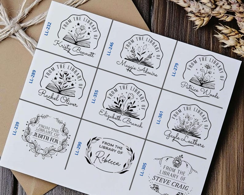 May include: Nine black and white rubber stamps with a book and floral design. Each stamp has a different name and the text "From the Library of" above the design. The stamps are arranged in a grid on a white background.