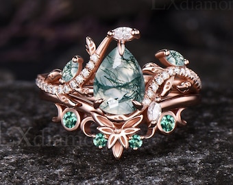 May include: A pear-shaped green agate gemstone ring with a delicate floral design. The ring is set in rose gold and features small green gemstones and diamonds.