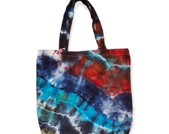May include: A blue, red and green tie-dye tote bag with a black canvas base.