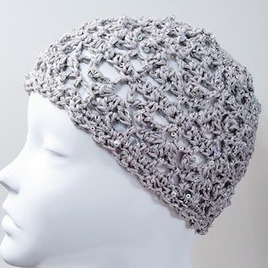 May include: A gray crocheted hat with a delicate openwork design and iridescent sequins.
