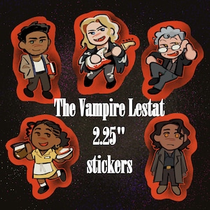 May include: Five cartoon-style character stickers with red outlines. The text reads The Vampire Lestat 2.25" stickers. Characters include a person with a book, a blonde musician with a guitar, a person with glasses, a server with coffee and pie, and a person in a coat.