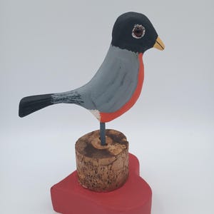 Robin male looking for love. Spring is here! Adolescent robin woodcarving.