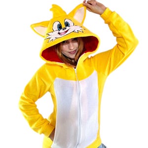May include: Yellow fleece zip-up hoodie with a white and red interior. The hood has a cartoon fox face with blue eyes and a red nose.