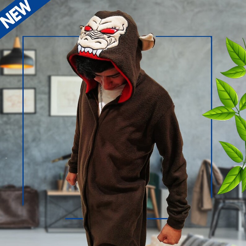 May include: Brown hooded jumpsuit with a red lining and a monkey face on the hood. The monkey face has red eyes and sharp teeth.