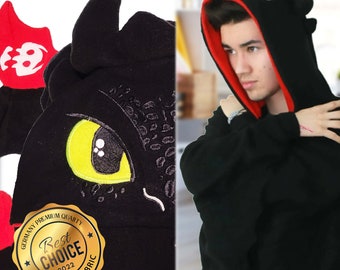 May include: Black hoodie with a dragon design on the hood. The hood has a red lining and a yellow eye. The hoodie has a tag that says "Germany Premium Quality Best Choice 2022 Ultimate Fabric".