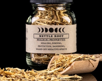 May include: A clear glass jar filled with dried nettle root, labeled with "NETTLE ROOT" and "MAGICAL PROPERTIES." A small wooden scoop holds more of the dried herb. The background is black, highlighting the product.