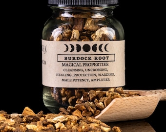 May include: A clear glass jar filled with burdock root, labeled with "BURDOCK ROOT" and "MAGICAL PROPERTIES." A wooden scoop and scattered root pieces are in the foreground. The background is black.
