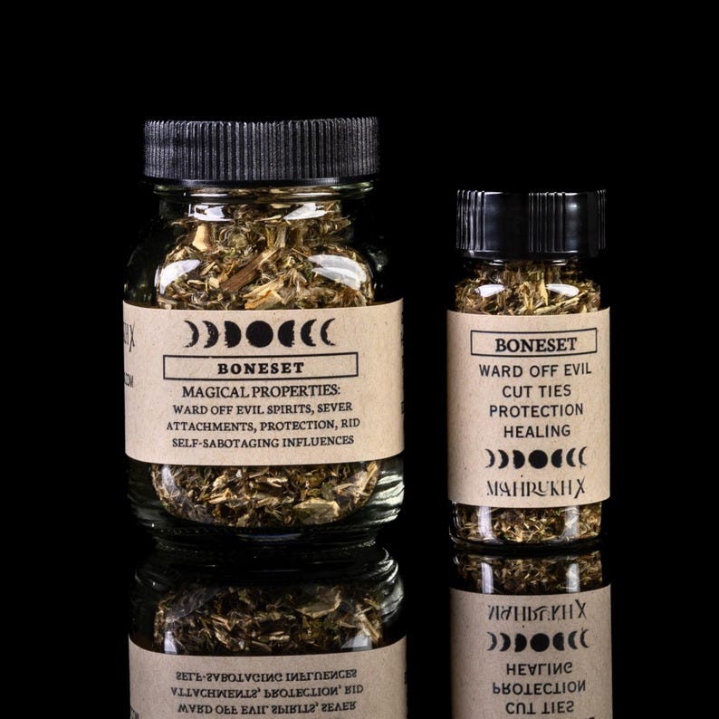May include: Two glass jars filled with dried herbs, labeled "Boneset" with magical properties listed. The smaller jar lists "Ward off evil, cut ties, protection, healing". Both jars have a crescent moon symbol.