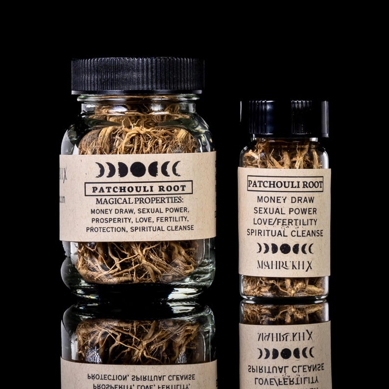 May include: Two glass jars filled with patchouli root, labeled with text about magical properties like money draw and sexual power. The jars have black lids and are set against a black background.