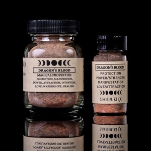 Może przedstawiać: Dwa szklane słoiki z czarnymi pokrywkami, wypełnione czerwonobrązowym proszkiem. Etykiety głoszą "Dragon's Blood" i wymieniają magiczne właściwości, takie jak ochrona i manifestacja. Na czarnym tle.