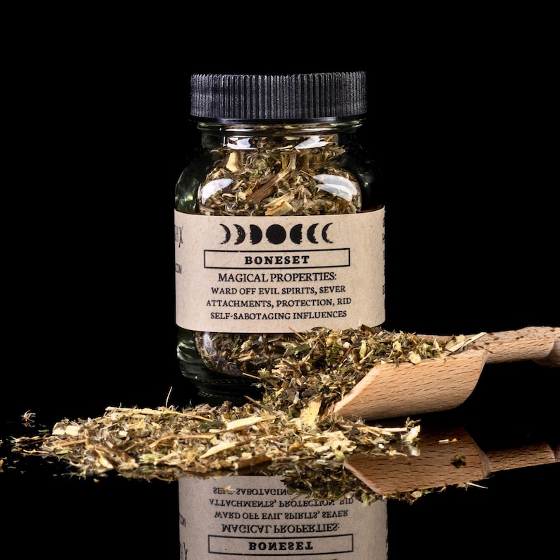 May include: A glass jar filled with dried herbs labeled "Boneset" with the text "Magical Properties: Ward off evil spirits, sever attachments, protection, rid self-sabotaging influences".