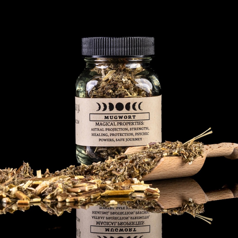 May include: A glass jar filled with dried mugwort herbs. The jar has a black lid and a brown label with the text 'MUGWORT' and 'MAGICAL PROPERTIES: ASTRAL PROJECTION, STRENGTH, HEALING, PROTECTION, PSYCHIC POWERS, SAFE JOURNEY'.