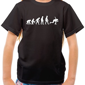 以下が含まれることがあります： 白い進化の図柄が描かれた黒いTシャツ。図柄は、スケートをする人物で終わる。