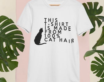 May include: White t-shirt with a black cat silhouette and the text "THIS T-SHIRT IS MADE FROM 100% CAT HAIR" printed on it.