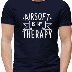 May include: A navy blue t-shirt with white text that reads "Airsoft is my therapy" with a banner above the word "therapy".