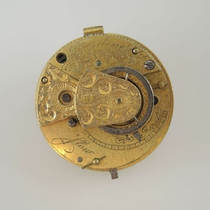K&ouml;nnte beinhalten: Eine goldene Taschenuhr mit aufwendigen Gravuren und der Inschrift "J. Flow" auf dem Zifferblatt.